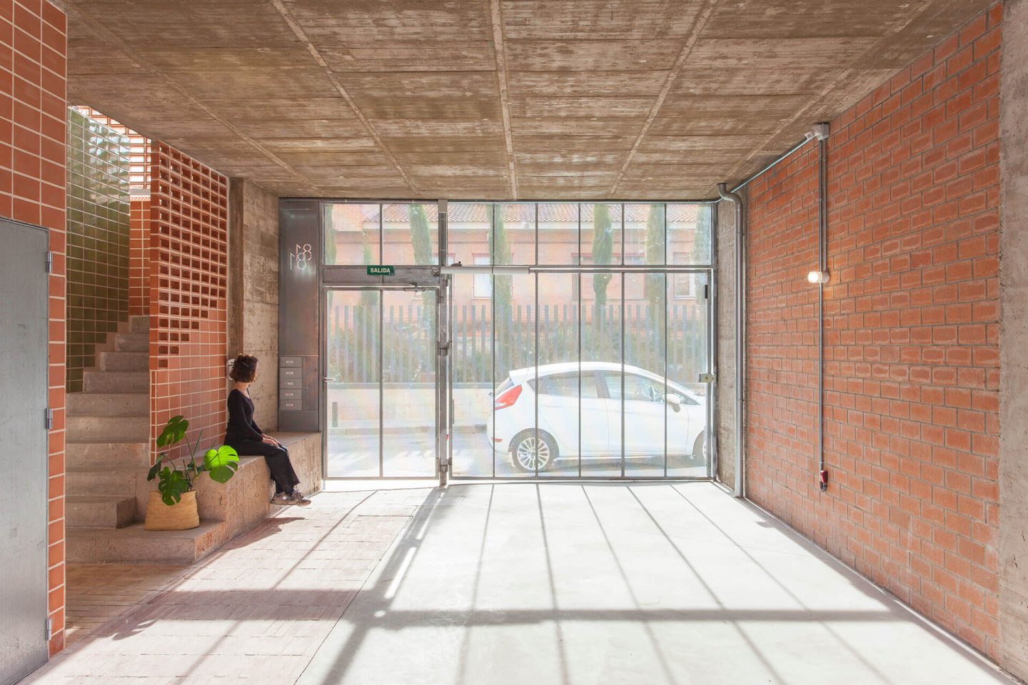 La entrada de la Casa Botijo destaca con ladrillos envejecidos, evocando la esencia comunitaria de las corralas madrileñas.